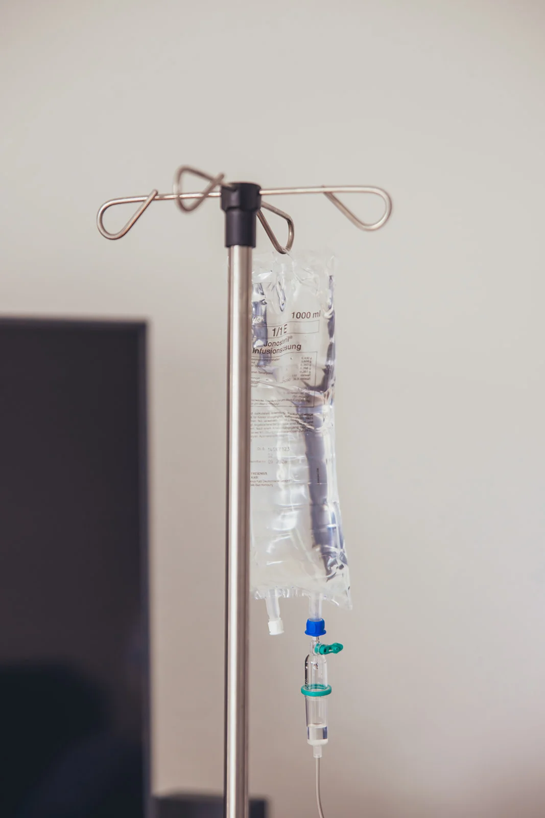 Infusionsständer mit einer intravenösen Infusion, symbolisch für die medizinische Versorgung und Unterstützung, die die Sozialstation Karlsruhe bietet. Das Bild steht beispielhaft für Dienstleistungen in der Fotografie, Projektbegleitung, Webdesign und Grafik, um das Engagement und die umfassende Betreuung im Bereich der häuslichen Pflege zu illustrieren.